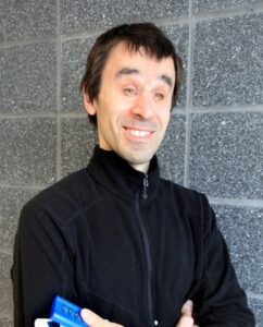 Head shot of Dan Zingaro wearing a black shirt and smiling